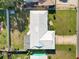 An aerial view of a home featuring a white tiled roof, green lawn, and an ample driveway at 2167 Timber Ln, Clearwater, FL 33763