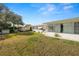 Spacious backyard with green grass, the exterior of a white house, and other houses in the distance at 2167 Timber Ln, Clearwater, FL 33763