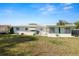 Wide backyard with green grass, a patio area, and the exterior of a white house at 2167 Timber Ln, Clearwater, FL 33763