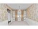 Bright dining room with chandelier, wainscoting, gold patterned wallpaper, and built-in shelving at 2167 Timber Ln, Clearwater, FL 33763