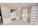 Light dining room featuring built-in shelving, chandelier, gold patterned wallpaper, and wainscoting at 2167 Timber Ln, Clearwater, FL 33763