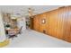 Open living room and dining room combo featuring a wood paneled wall, ceiling fan, and backyard access at 2167 Timber Ln, Clearwater, FL 33763