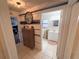 Hallway featuring a decorative wall treatment, a neutral colored storage cabinet, and bathroom access at 3415 Phillips St, Tampa, FL 33619