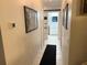 Hallway with neutral walls and floors, featuring framed art and a glimpse into a well-lit bathroom at 3415 Phillips St, Tampa, FL 33619