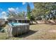 Backyard showcasing an above-ground pool, mature trees, and a screened lanai, creating a private oasis at 530 Napa Valley Cir, Valrico, FL 33594