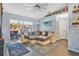 Bright living room with a large sectional couch, ceiling fan, and sliding glass doors to the screened patio at 530 Napa Valley Cir, Valrico, FL 33594