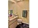 Cozy bathroom with neutral floral wallpaper, toilet, and simple vanity at 11231 Dollar Lake Dr # 1, Port Richey, FL 34668