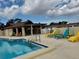 Community pool with tables, chairs and lounge chairs for residents to enjoy on a sunny day at 11231 Dollar Lake Dr # 1, Port Richey, FL 34668