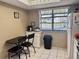 Bright kitchen eat-in area featuring tile floors, black chairs, and a view from the window at 11231 Dollar Lake Dr # 1, Port Richey, FL 34668