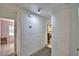 Hallway area with white walls leading into bedroom, showing thermostat and textured walls at 1413 May St, Lutz, FL 33548