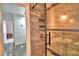 Shower featuring marble tile walls, a sliding glass door, and a brass shower head at 1413 May St, Lutz, FL 33548