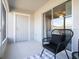 Relaxing patio with modern chair, neutral colors and a sliding glass door that leads to the home's interior at 2763 Walden Town Cir, Plant City, FL 33566