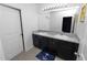 Bathroom with double sink vanity, a large mirror and dark cabinetry at 8680 Falling Blue Pl, Riverview, FL 33578