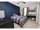 Comfortable bedroom showcases a navy accent wall and a bed with gray bedding at 8680 Falling Blue Pl, Riverview, FL 33578