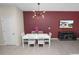 Dining room featuring a white table, modern light fixture, and a deep accent wall at 8680 Falling Blue Pl, Riverview, FL 33578