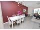 Dining room featuring a white table, modern light fixture, and an accent wall at 8680 Falling Blue Pl, Riverview, FL 33578