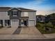 Charming townhome featuring a gray facade, attached garages, and neatly landscaped front yard at 8680 Falling Blue Pl, Riverview, FL 33578