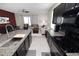 Modern kitchen with dark cabinets, granite countertops, and view into the living area at 8680 Falling Blue Pl, Riverview, FL 33578