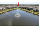 Serene pond with a central fountain surrounded by modern residential townhomes at 8680 Falling Blue Pl, Riverview, FL 33578