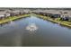 Scenic aerial shot of a pond with a fountain bordered by residential townhomes at 8680 Falling Blue Pl, Riverview, FL 33578