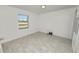 Well-lit bedroom with a large window and neutral tile flooring at 9608 Theresa Dr, Thonotosassa, FL 33592