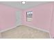 Bedroom with bright pink walls, tile flooring, and a window, creating a cozy atmosphere at 9608 Theresa Dr, Thonotosassa, FL 33592