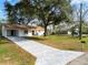 Quaint single-story home with a long driveway and a well-maintained front lawn at 9608 Theresa Dr, Thonotosassa, FL 33592