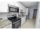 Updated kitchen featuring white cabinetry, granite countertops, and stainless-steel appliances at 9608 Theresa Dr, Thonotosassa, FL 33592