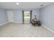 Bright, open-concept living area with tile flooring, natural light, and an adjacent dining space at 9608 Theresa Dr, Thonotosassa, FL 33592