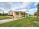 Yellow single-story home with covered porch, landscaped yard, and paved driveway at 3100 Goldfinch Ter, Englewood, FL 34224