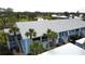 Aerial view of a light blue condo building with white roof and palm trees at 448 Cerromar Rd # 286, Venice, FL 34293