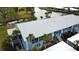 Aerial view of a light blue condo building with white roof and palm trees at 448 Cerromar Rd # 286, Venice, FL 34293