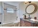 Bathroom featuring marble countertop, oval mirror, and tiled shower and tub combo at 1061 Owl Dr, Englewood, FL 34223