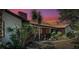 Attractive home with brick accents, lush landscaping, and a serene, colorful evening sky at 1061 Owl Dr, Englewood, FL 34223