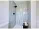 Modern shower featuring gray tiled walls, niche, and rain shower head in updated bathroom at 1061 Owl Dr, Englewood, FL 34223