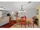 Open concept dining area with red chairs, a farmhouse table and view of the living room at 566 Viridian St, Englewood, FL 34223