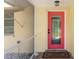 A coral front door with a glass panel in a screened porch at 566 Viridian St, Englewood, FL 34223