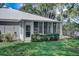 Rear view of home showcasing sunroom and well-manicured lawn at 429 Wexford Cir # 75, Venice, FL 34293