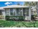 Rear view of home showcasing sunroom and well-manicured lawn at 429 Wexford Cir # 75, Venice, FL 34293