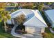 Aerial view of single-Gathering home with tile roof, two-car garage, and landscaped yard at 664 Silk Oak Dr, Venice, FL 34293