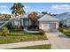 Single-Gathering home exterior, tile roof, two-car garage, and landscaped yard at 664 Silk Oak Dr, Venice, FL 34293