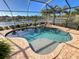 Inviting screened pool with brick patio and lake view at 11613 Marathon Cir, Venice, FL 34293