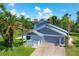 Two-car garage and front yard with palm trees at 5885 Denison Dr, Venice, FL 34293