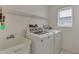 Bright laundry room with washer, dryer, and utility sink at 5888 Garfield Rd, Venice, FL 34293