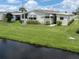 Mobile home near the water with a grassy yard at 423 Pirates Pt, North Port, FL 34287