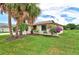 Landscaped yard with palm trees and flowering bushes at 1411 Strada D Argento, Venice, FL 34292