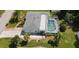 An aerial view of a home with a screened pool, palm trees, and a well-maintained lawn at 221 Malvern Dr, Venice, FL 34293