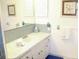 Bright bathroom features a white vanity with granite countertop and nautical-themed decor at 221 Malvern Dr, Venice, FL 34293