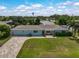 Light blue house with a paved driveway, landscaping, and pergola at 1099 Nokomis S Ave, Venice, FL 34285