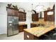 Modern kitchen with rich wood cabinetry, granite countertops, and stainless steel appliances at 9 Bunker Ln, Rotonda West, FL 33947